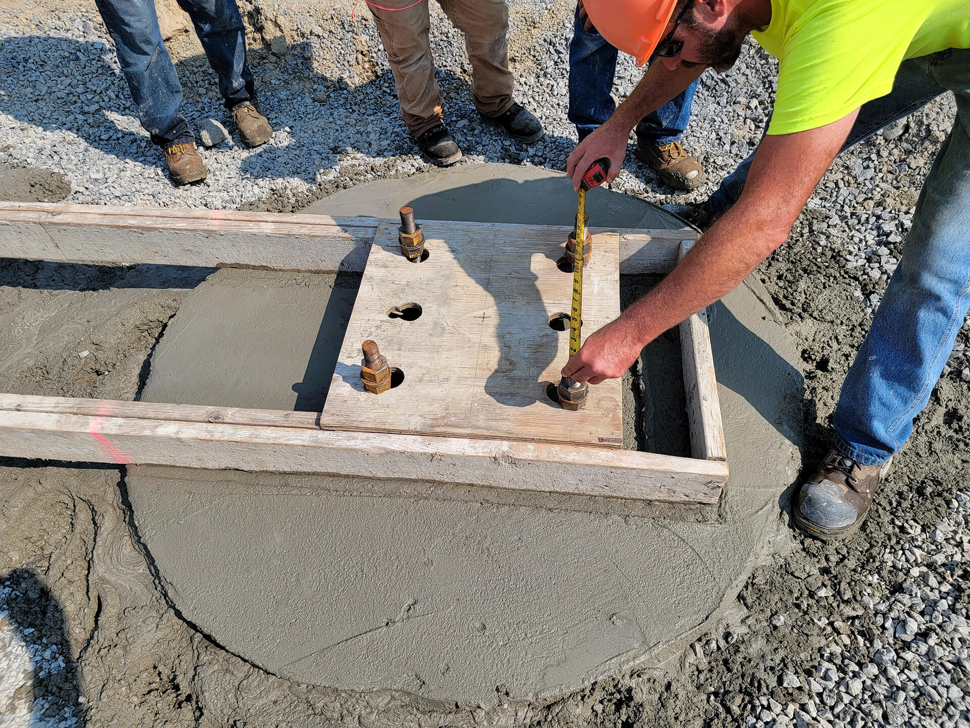 Construction worker measuring distance between bolts for a cement cover